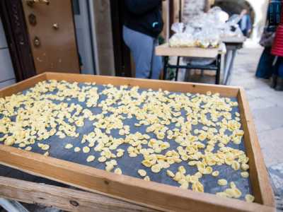 Lasciamo Angela per spostare la nostra attenzione sul banchetto di fronte. Anche qui sul telaio giacciono piccole orecchiette...